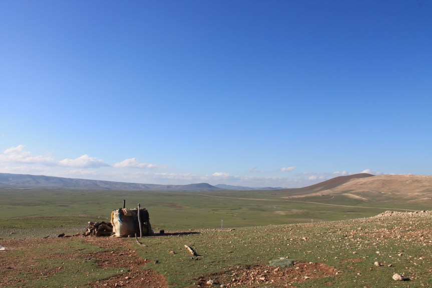 small shack among rolling green hills