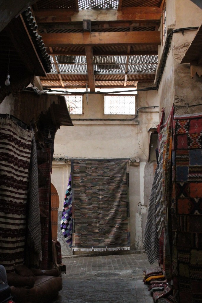 artisan rugs hanging on old city walls