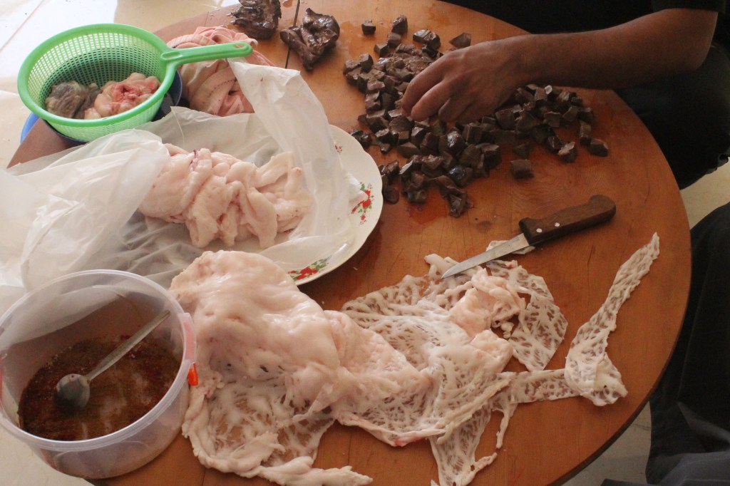chopped liver and strips of fat on wooden table