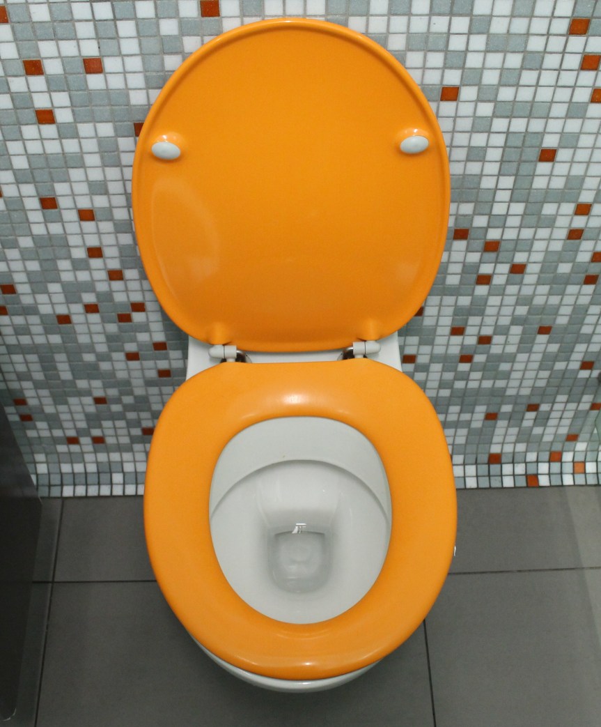 orange toilet with lid up