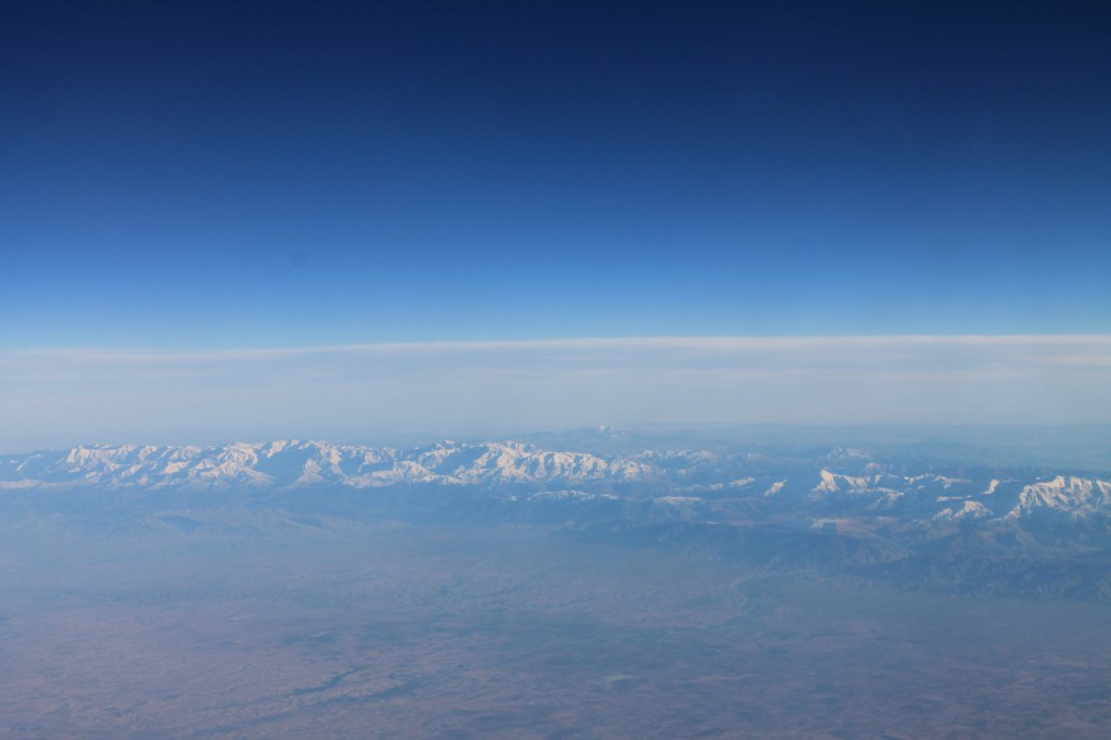 aerial view of snow-capped mountains and desert