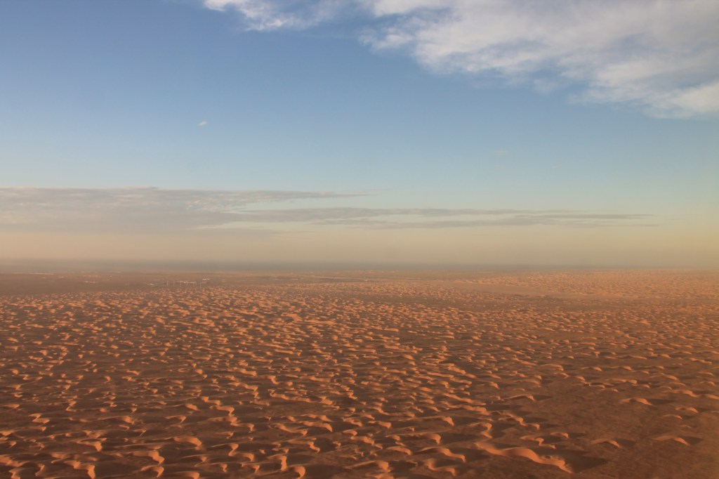 aerial view of expanse of desert and blue sky