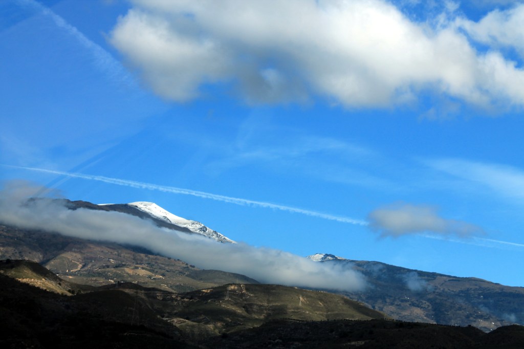 snow-tipped mountains above clouds