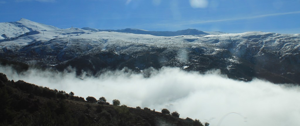snow-tipped mountains above clouds