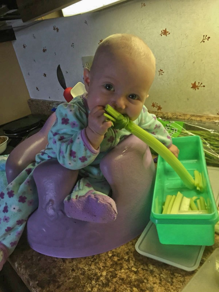 baby girl chewing on celery stalks