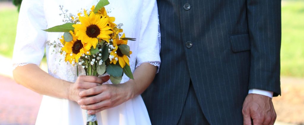 bride and groom with sunflower bouquet