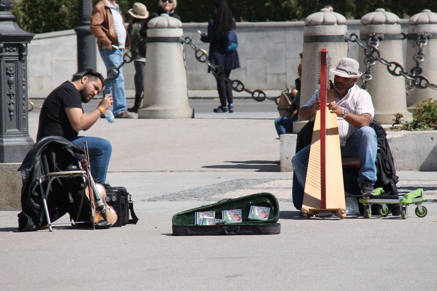 man taking photo of man playing harp