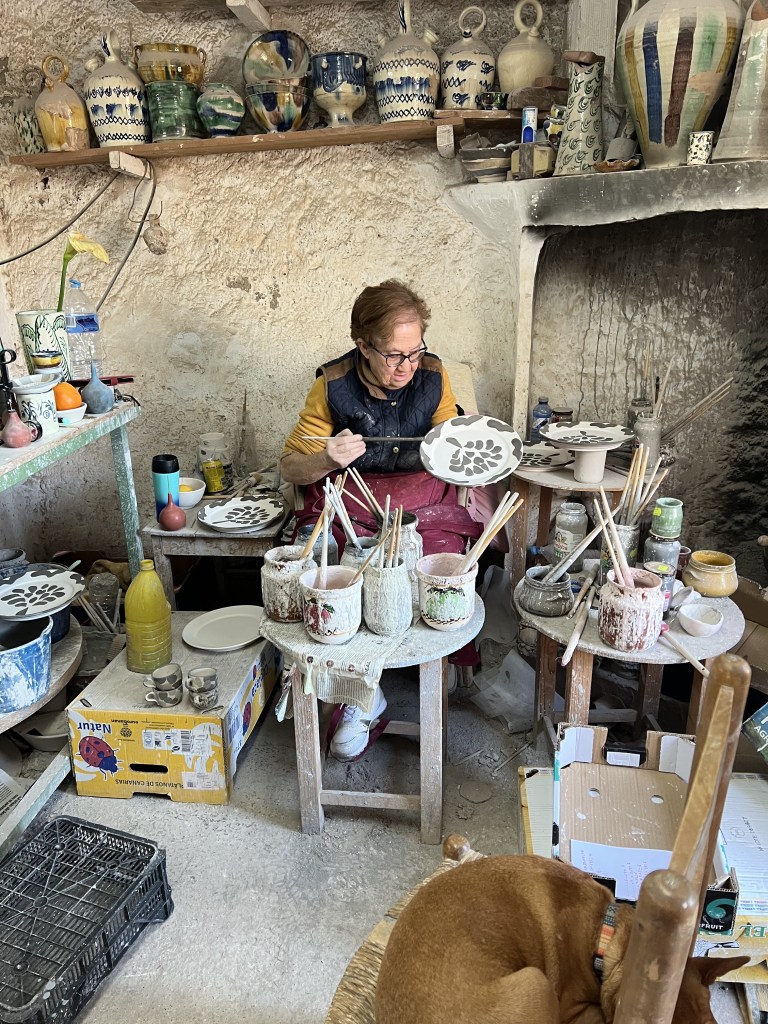 elderly woman painting pottery