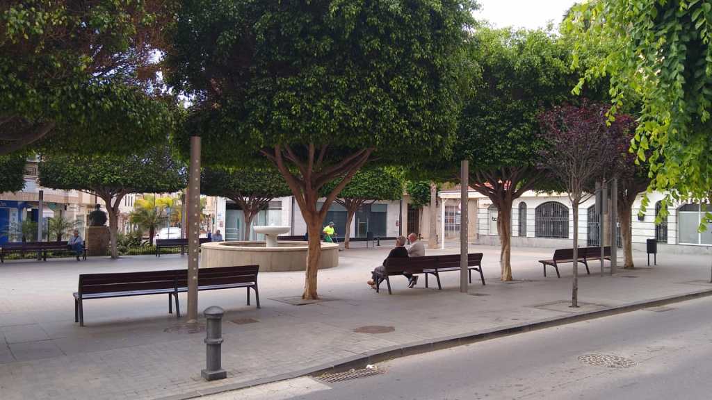Two men on a park bench in a plaza
